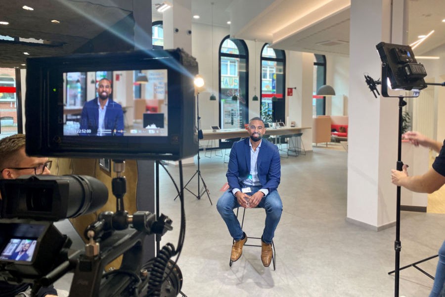 Quelle: Sparkasse Hannover Mann sitzt auf einem Stuhl am Filmset. - Quelle: Sparkasse Hannover