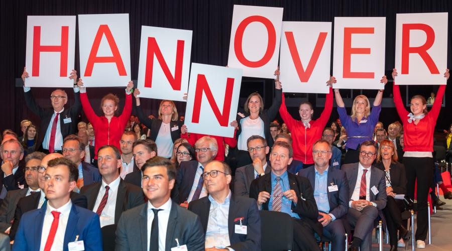 Mitarbeitende der Sparkassen halten ein Schild mit der Aufschrift Hannover hoch. - Quelle: DSGV