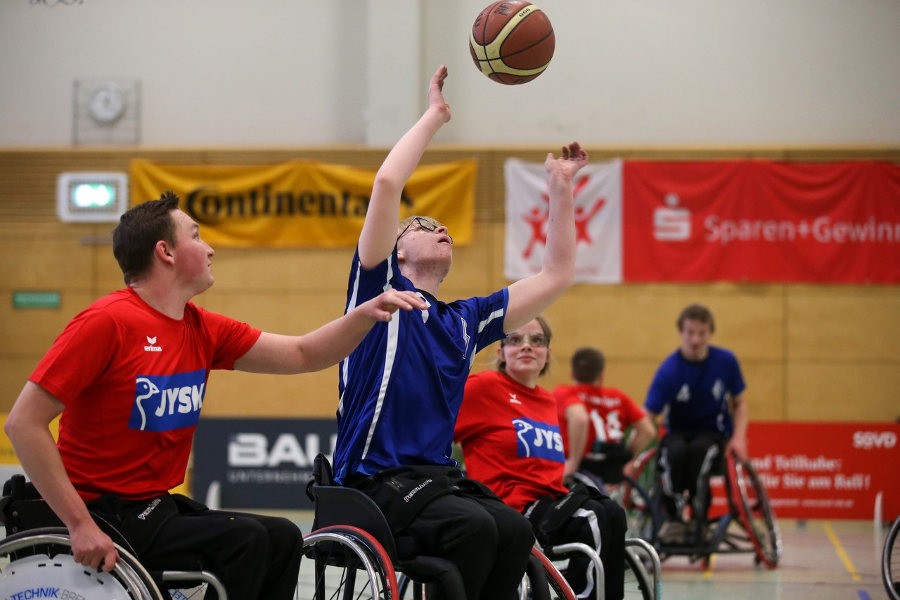 Rollstuhlbasketballer fängt einen Basketball. Foto: Maike Lobback