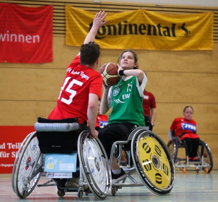 Rollstuhlbasketballerin wirft einen Basketball. Foto: Maike Lobback