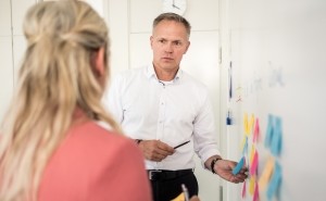 Mann erklärt Inhalte an einem Whiteboard. Quelle: SVN, Insa Hagemann