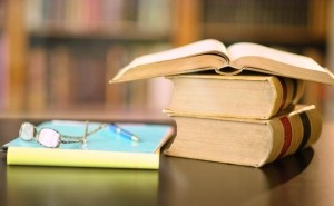 alte Bücher und eine Brille liegen auf einem Tisch in der Bibliothek. - Quelle: DSV, getty